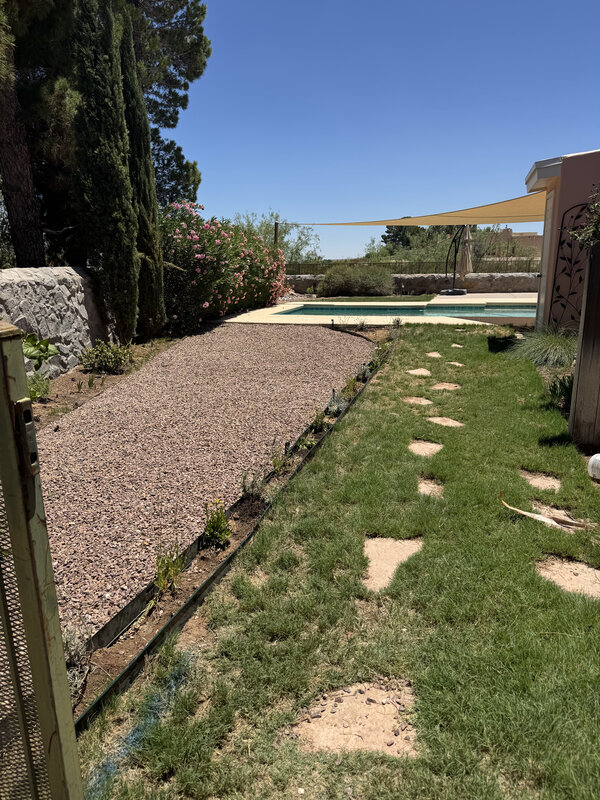 Drip irrigation system around a pool area with gravel landscaping in Las Cruces