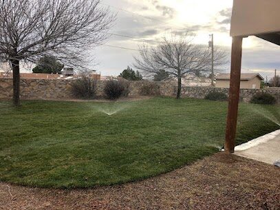 Sprinkler system running on a Las Cruces residential lawn