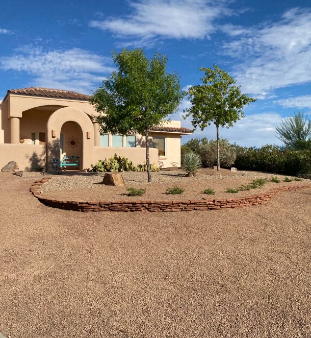 Custom stone border separating planting beds in Las Cruces