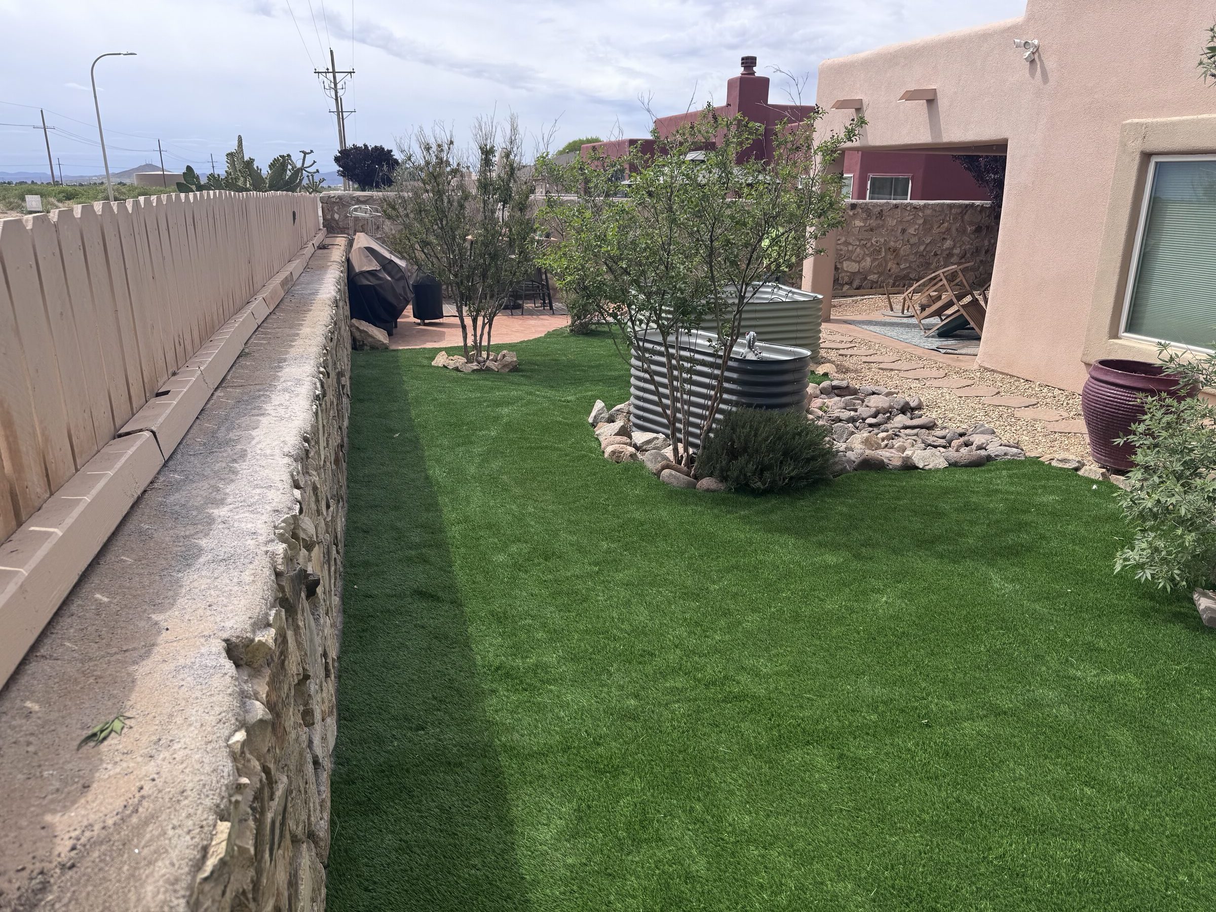 Clean artificial turf side yard in Las Cruces maintained by Brainard's Greenscapes