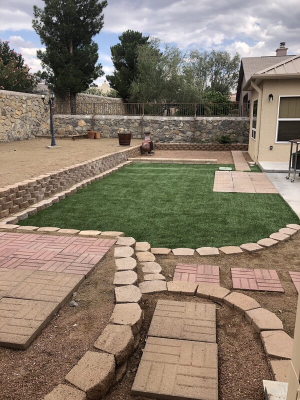 Retaining wall with turf and paver walkway by Brainard's Greenscapes