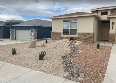 New construction xeriscape with dry creek bed, accent boulders, and stone pillar accents