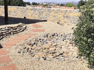 Stacked stone and flagstone hardscape detail with gravel and stone retaining wall