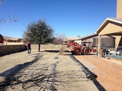 Kubota tractor spreading gravel on a residential landscaping project