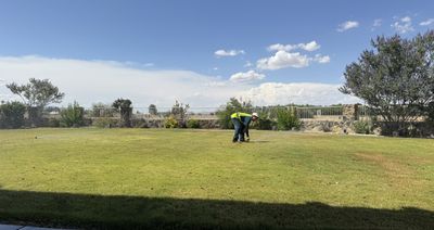 Crew member performing lawn maintenance on a large residential property in Las Cruces