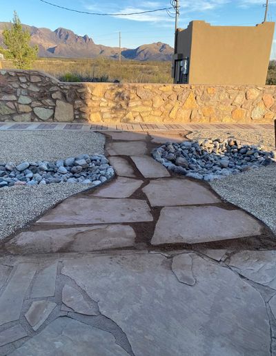 Flagstone walkway with river rock borders and Organ Mountain views at sunset