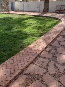 Fresh sod lawn with herringbone brick paver walkway and flagstone path