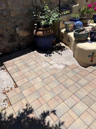 Brick pavers fitted around stucco feature wall with Talavera pottery and plantings