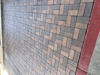 Herringbone brick paver patio with multi-tone pavers and red soldier-course border