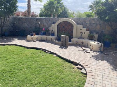 Brick paver patio installation in progress showing scope of backyard project with southwestern feature wall