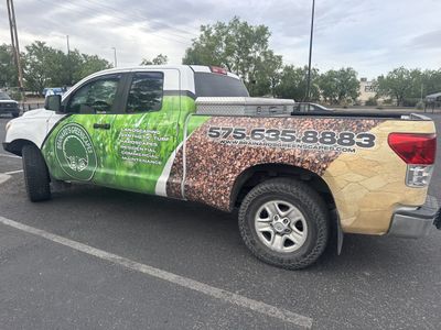 Brainard's Greenscapes branded crew truck with full vehicle wrap in a Las Cruces parking lot