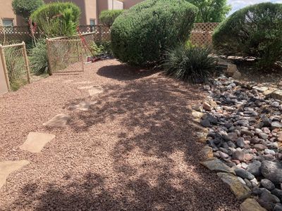 Flagstone stepping stone path through a gravel xeriscape bed leading to a side gate
