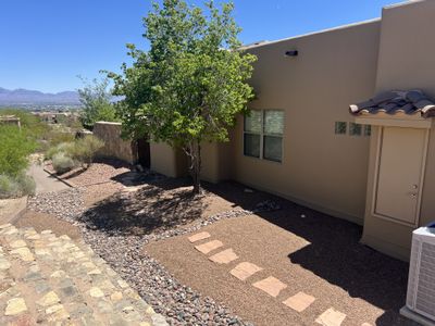 Side yard xeriscape with stepping stones, river rock border, and shade tree overlooking the Mesilla Valley