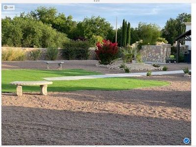 Estate landscape with shaped turf, stone bench, bougainvillea, and stone retaining wall
